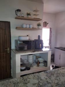 a kitchen with a counter with dishes and a microwave at VillaWamu in Lusaka +16 photos