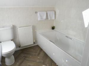a bathroom with a white tub and a toilet at Hamlet Cottage sleeps 3-4 Stratford upon Avon in Stratford-upon-Avon +16 photos