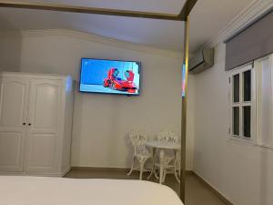 a bedroom with a bed and a tv on the wall at Hannabi Hotel in Boca Chica