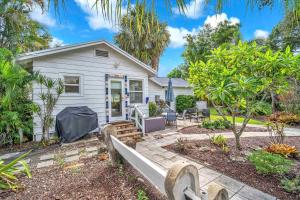 a white house with a bench in front of it at Bromeliad Bungalow - Downtown Cottage in Fort Lauderdale