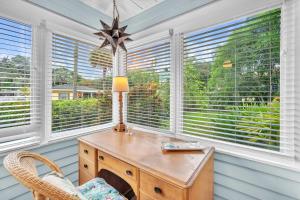 ein Heimbüro mit einem Holzschreibtisch und Fenstern in der Unterkunft Bromeliad Bungalow - Downtown Cottage in Fort Lauderdale