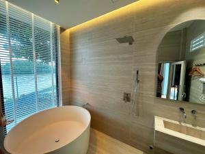 a bathroom with a large tub and a mirror at Phú Xuân Homestay - Gần Dốc Hoàng Hôn, Phòng Rộng View Sông in Phan Thiet