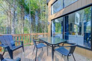una veranda schermata con tavolo e sedie in vetro di Chalet Le Baikal a Pont-Rouge