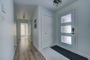 un corridoio con pareti bianche e una porta di Chalet Le Baikal a Pont-Rouge