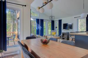 una sala da pranzo e un soggiorno con un tavolo in legno di Chalet Le Baikal a Pont-Rouge