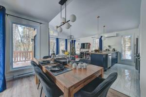 una cucina e una sala da pranzo con tavolo e sedie in legno di Chalet Le Baikal a Pont-Rouge
