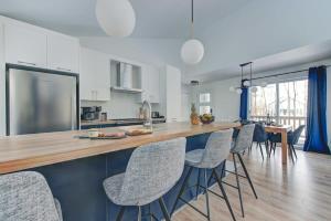 una cucina e una sala da pranzo con bancone e sedie di Chalet Le Baikal a Pont-Rouge Altre 46 foto