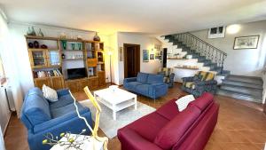 a living room with blue couches and a staircase at Villino Blu 12 pax villa in Tuscany with private pool in Loro Ciuffenna