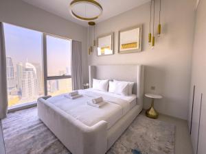 a bedroom with a large white bed with a large window at GRANDE RESIDENCES with a direct Burj Khalifa view and Private Fountain Show at 62nd floor with DXB AIRPORT VIP Shuttle for 6 guests in Dubai