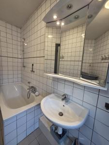 une salle de bain avec un lavabo, une baignoire et un miroir dans l'établissement Bel-étage cosy 2 chambres proche Charleroi-Airport, à Charleroi