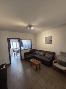 un salon avec un canapé et une table dans l'établissement Bel-étage cosy 2 chambres proche Charleroi-Airport, à Charleroi