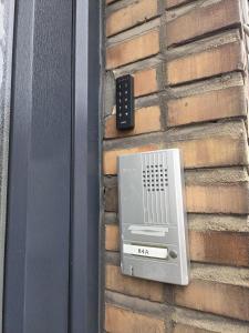 une télécommande sur le côté d'une maison avec un mur de briques dans l'établissement Bel-étage cosy 2 chambres proche Charleroi-Airport, à Charleroi 2 autres photos