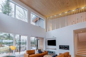 a living room with a couch and a tv at Villa Birdie in Pont-Rouge
