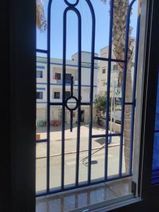 a window view of a street with a clock outside at Hotel Rama in Oued Laou
