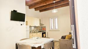 a kitchen and living room with a table and a television at Jasmine House Ustica heart in Ustica