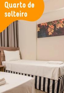 zwei Betten in einem Zimmer mit den Worten Quattro be Santiago in der Unterkunft Solar das Aguas Resort in Olímpia