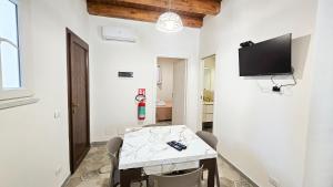 a dining room with a table and a tv on the wall at Jasmine House Ustica heart in Ustica