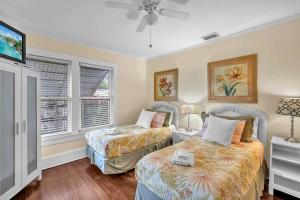 a bedroom with two beds and a flat screen tv at Blue Reverie - Downtown Cottage in Fort Lauderdale