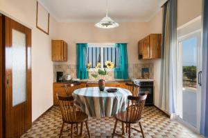 cocina con mesa y sillas y cocina con cortinas azules en Sirens House, en Tavronitis