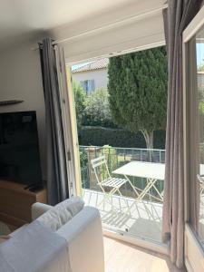 a living room with a couch and a sliding glass door at Lorette Hideway in Saint-Tropez +12 photos