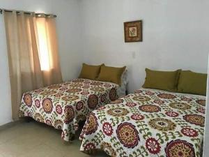due letti uno accanto all'altro in una camera da letto di Hotel Tamasons a Tamasopo