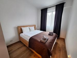 a small bedroom with a bed and a window at Panorama Pine Retreat - Spacious 2-Bedroom Flat in Predeal