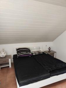 a bedroom with a black bed with two pillows at Zimmer mit Weitblick in Weinregion in Bad Kreuznach