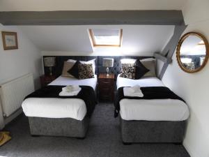 une chambre d'hôtel avec deux lits et un miroir dans l'établissement The Shakespeare Lodge - Sleeps up to 12 - 2 HOT TUBS, à Stratford-upon-Avon