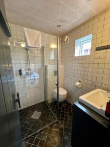 une salle de bains avec douche, toilettes et lavabo dans l'établissement Magnusbua in the centre of Reine, à Moskenes 17 autres photos