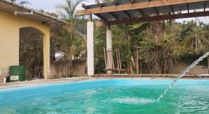 a swimming pool with a water fountain at Casa Dona Flor in Morretes