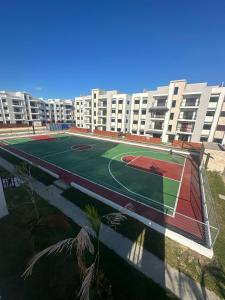 - un court de tennis en face d'un grand immeuble dans l'établissement Santo Domingo Tropical Peaceful Escape Ocean Front Near Boca Chica Airport, à La Golondrina