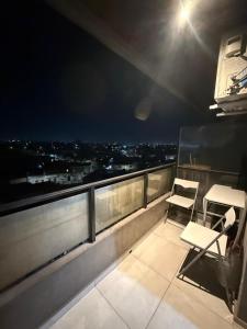 d'un balcon avec deux chaises et une vue sur la ville. dans l'établissement CHINO I, à San Miguel de Tucumán