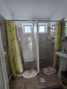 a bathroom with a shower with yellow shower curtains at Rodica Apartment in Sibiu
