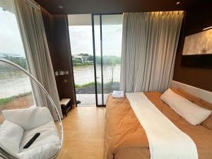 a hotel room with a bed and a large window at Phú Xuân Homestay - Gần Dốc Hoàng Hôn, Phòng Rộng View Sông in Phan Thiet