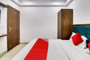 a bedroom with a bed with red pillows at Hotel O ANNU RESIDENCY in Alīgarh