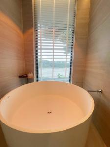 a large bath tub in a bathroom with a window at Phú Xuân Homestay - Gần Dốc Hoàng Hôn, Phòng Rộng View Sông in Phan Thiet