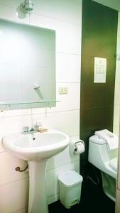 a bathroom with a sink and a toilet and a mirror at Samay Misti Hostal in Arequipa