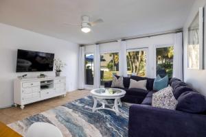 a living room with a blue couch and a tv at Steps to the Beach! Resort Access & Golf Cart Included! Dog Friendly in Fripp Island