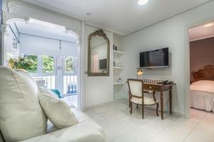 a bedroom with a desk and a bed and a television at Apartamentos Las Brisas in Santander