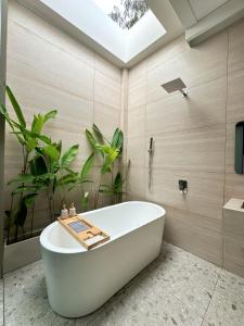 a bath tub in a bathroom with plants at Phú Xuân Homestay - Gần Dốc Hoàng Hôn, Phòng Rộng View Sông in Phan Thiet