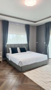 a bedroom with a large bed and a window at Vela Pool Villa Hatyai in Sathani Khlong Rian +51 photos