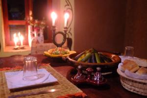 a table with a bowl of food and a plate of bread at The dune camp in Mhamid