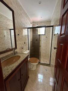a bathroom with a toilet and a sink and a shower at Cobertura Duplex Prainha 304 in Arraial do Cabo