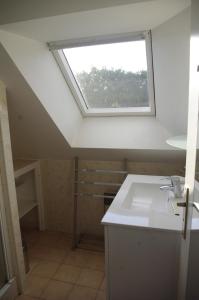 ein Badezimmer mit Waschbecken und Fenster in der Unterkunft Gîte Penn trech 2 chambres in Arradon