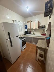 eine Küche mit einem weißen Kühlschrank und einem Herd in der Unterkunft APT PERÓ Livio Viviani in Cabo Frio