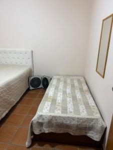 ein Schlafzimmer mit einem Bett und einem Spiegel an der Wand in der Unterkunft APT PERÓ Livio Viviani in Cabo Frio + 4 Fotos