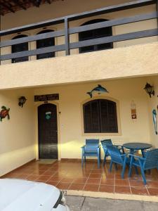 ein Gebäude mit drei blauen Stühlen und einem Tisch in der Unterkunft APT PERÓ Livio Viviani in Cabo Frio