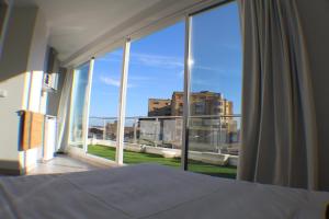 a bedroom with a bed and a large window at Bike Suite in Figueira da Foz