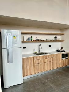 una cucina con frigorifero bianco e armadietti in legno di Finca Torcivia Luna a Vista Flores