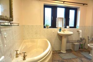 a bathroom with a tub and a sink and a toilet at The Peak View - Holmfirth in Cartworth +33 photos